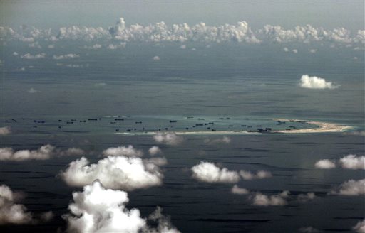 FILE - In this May 11, 2015, file photo, an aerial photo taken through a glass window of a military plane shows China's alleged on-going reclamation of Mischief Reef in the Spratly Islands in the South China Sea. As expectations grow that the U.S. Navy will directly challenge Beijingâ??s South China Sea claims, China is engaging in some serious image-building for its own military by hosting two international security forums beginning Friday, Oct. 16, 2015. (Ritchie B. Tongo/Pool Photo via AP, File)